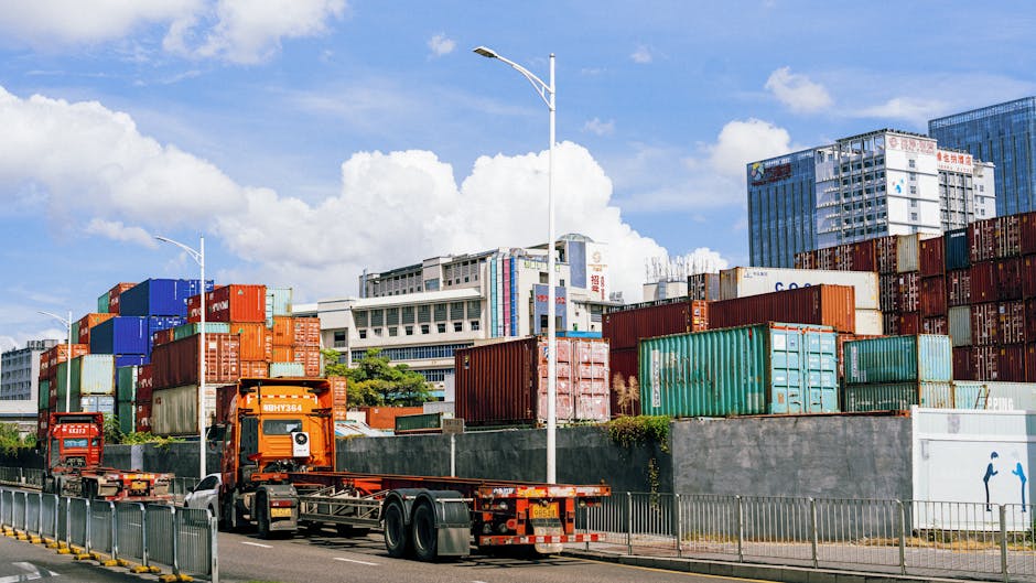 Colorful shipping containers stack at an industrial port under clear skies.
